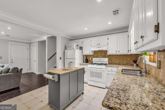 kitchen featuring white appliances, sink, a center island, white cabinetry, and light hardwood / wood-style floors