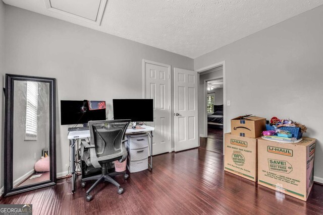 home office featuring dark wood-type flooring and a textured ceiling