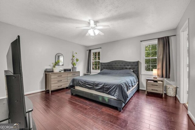 bedroom featuring multiple windows, a textured ceiling, ceiling fan, and dark hardwood / wood-style flooring