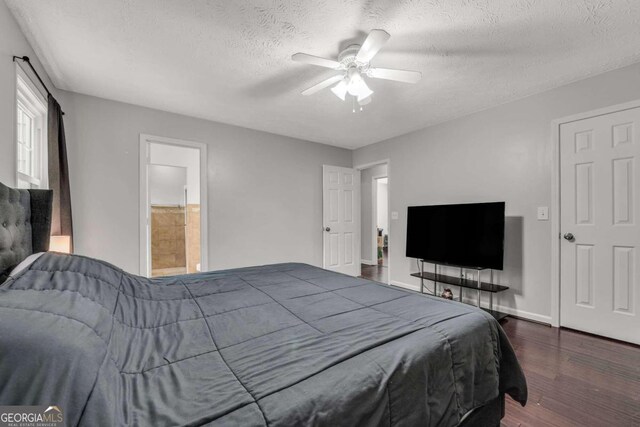 bedroom with dark hardwood / wood-style floors, ensuite bathroom, a textured ceiling, and ceiling fan