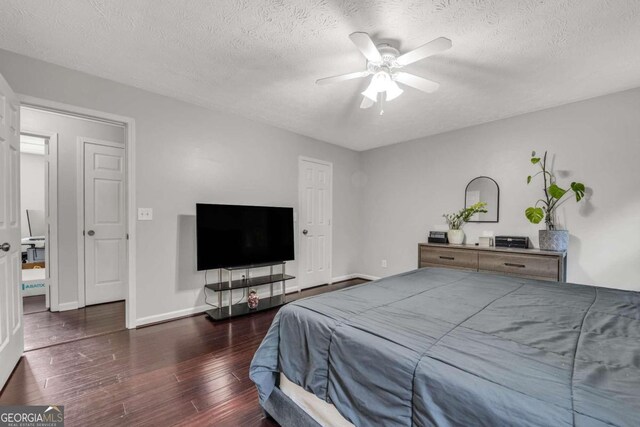 bedroom featuring a textured ceiling, dark wood-type flooring, and ceiling fan