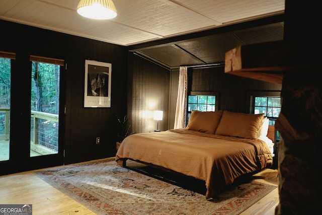 bedroom featuring hardwood / wood-style floors and wood walls