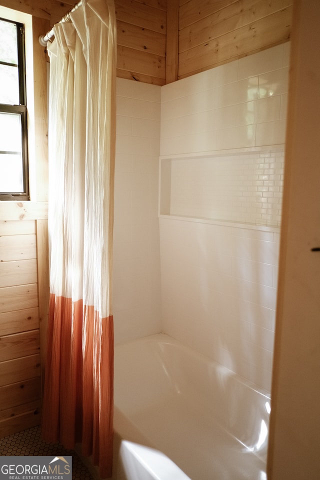 bathroom featuring shower / tub combo with curtain and wood walls