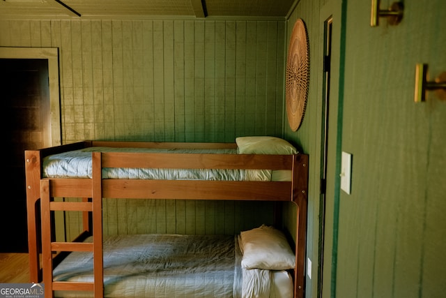 bedroom featuring wood walls