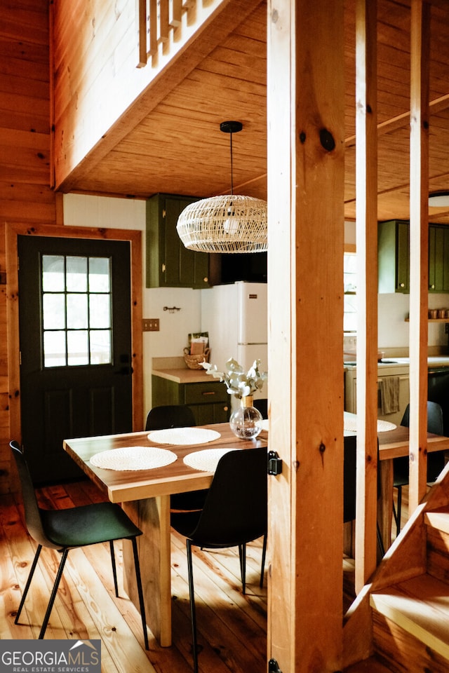 dining area featuring wood ceiling, wood walls, and wood-type flooring