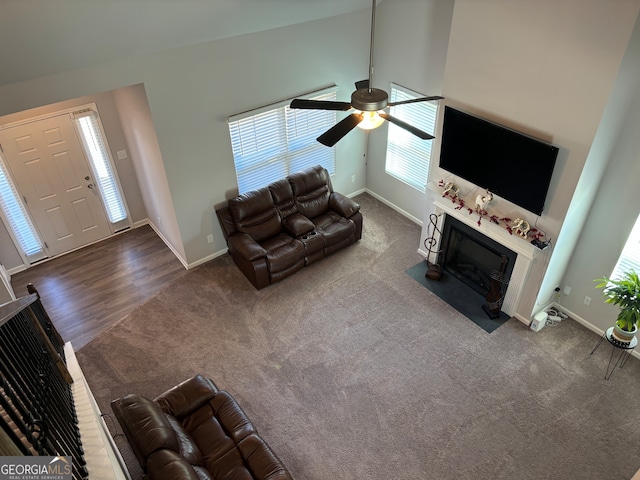 unfurnished living room featuring high vaulted ceiling, dark wood-type flooring, and ceiling fan