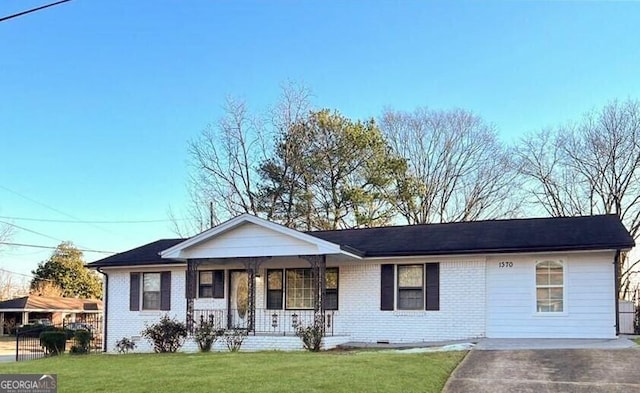 single story home with crawl space, covered porch, a front yard, and brick siding