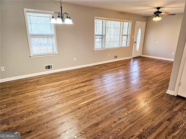 interior space with baseboards, dark wood-type flooring, visible vents, and a healthy amount of sunlight