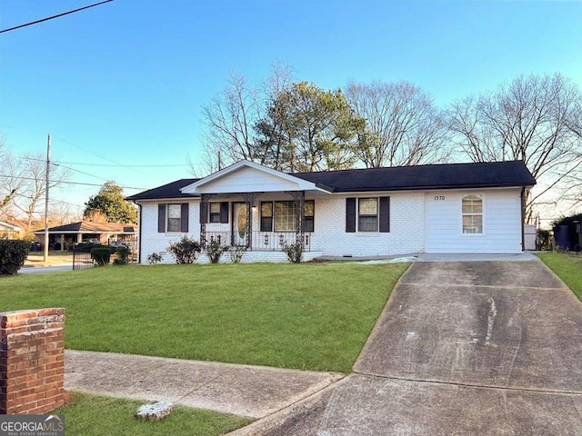 ranch-style home featuring covered porch, driveway, a front lawn, and brick siding