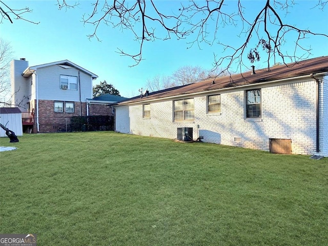 back of house with cooling unit, crawl space, brick siding, and a lawn