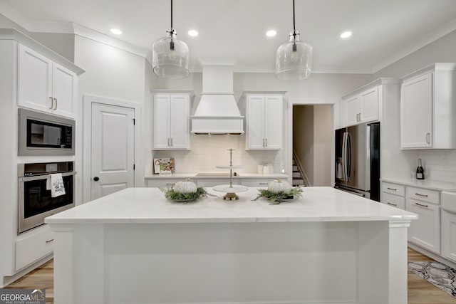 kitchen with hanging light fixtures, light stone countertops, white cabinetry, custom exhaust hood, and appliances with stainless steel finishes