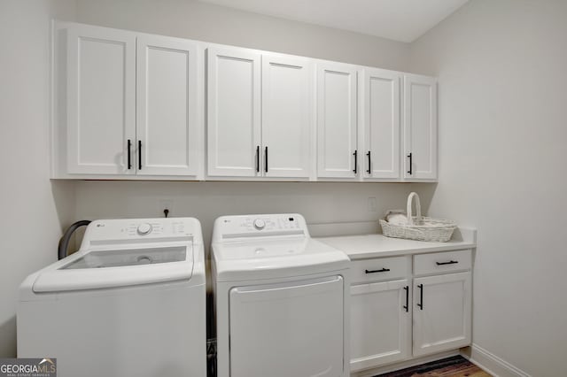 washroom with dark wood-type flooring, independent washer and dryer, and cabinets