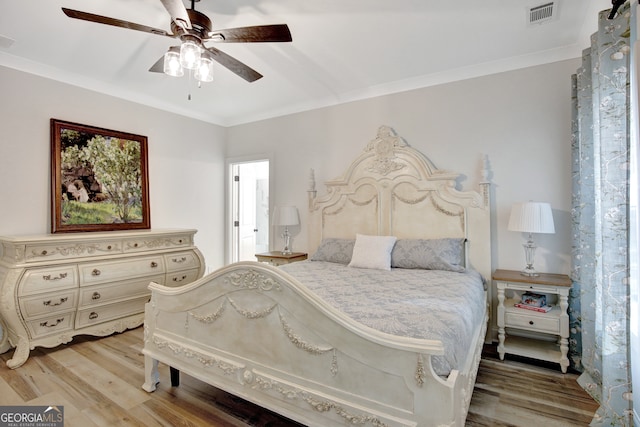 bedroom featuring ornamental molding, hardwood / wood-style floors, and ceiling fan