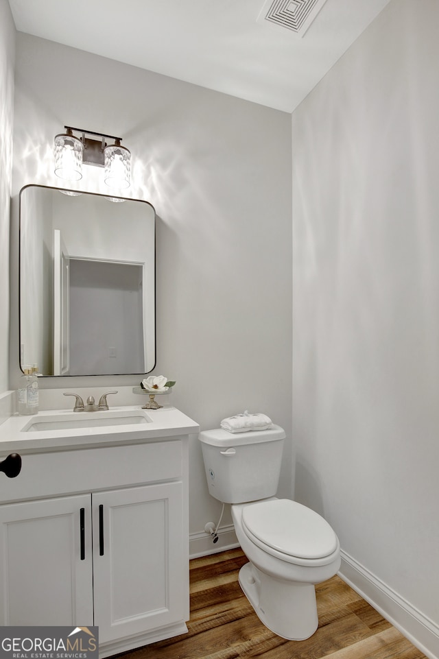 bathroom featuring vanity, toilet, and hardwood / wood-style flooring