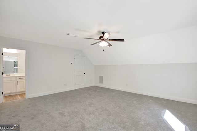 bonus room with light carpet, lofted ceiling, and ceiling fan