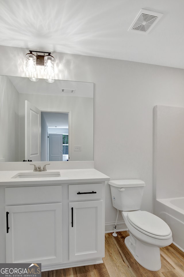 bathroom featuring vanity, toilet, and hardwood / wood-style flooring