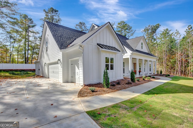 modern farmhouse style home featuring covered porch, a front yard, and a garage