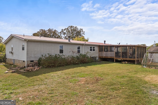 back of property featuring central air condition unit, a lawn, and a sunroom