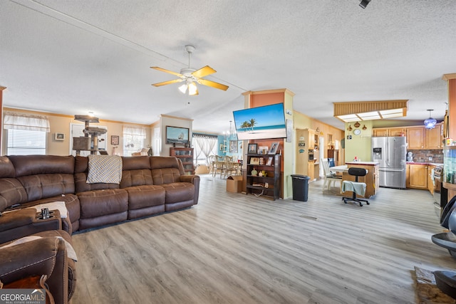 living room featuring light hardwood / wood-style floors, ceiling fan, a textured ceiling, and vaulted ceiling