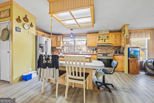 kitchen with stainless steel electric range, hanging light fixtures, a kitchen bar, and a healthy amount of sunlight