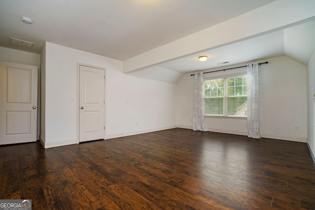 additional living space featuring dark wood-type flooring and lofted ceiling with beams