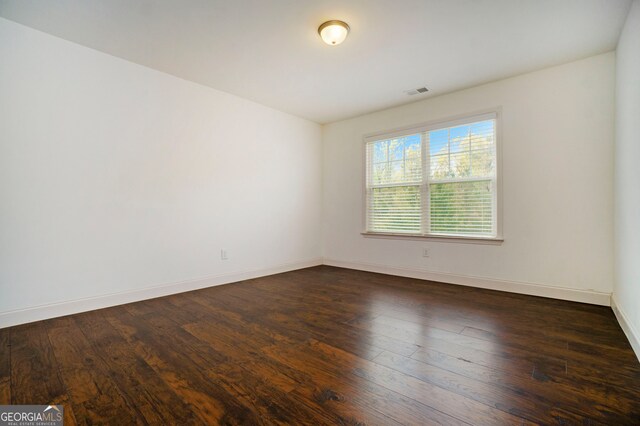 unfurnished room with dark hardwood / wood-style flooring