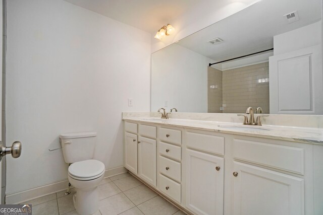 bathroom featuring toilet, tile patterned flooring, vanity, and tiled shower