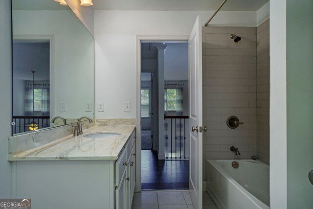 bathroom with tiled shower / bath, vanity, and tile patterned flooring