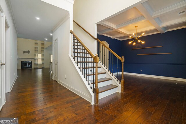 stairs featuring coffered ceiling, wood-type flooring, beamed ceiling, and ornamental molding