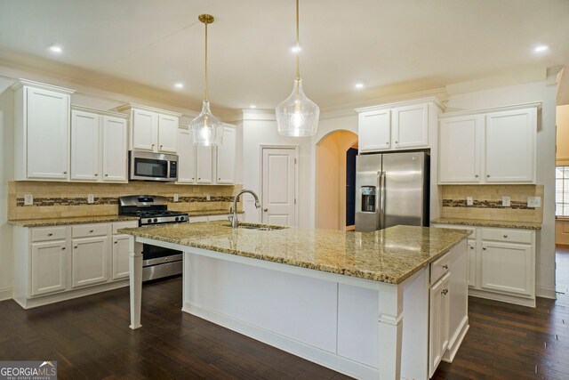 kitchen with sink, appliances with stainless steel finishes, decorative light fixtures, and white cabinetry