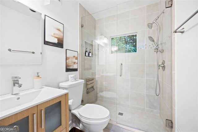 bathroom featuring toilet, walk in shower, vanity, and tile patterned floors