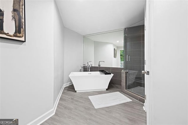 bathroom featuring separate shower and tub and hardwood / wood-style flooring