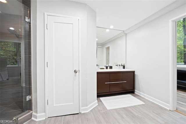 bathroom with vanity, an enclosed shower, and hardwood / wood-style flooring