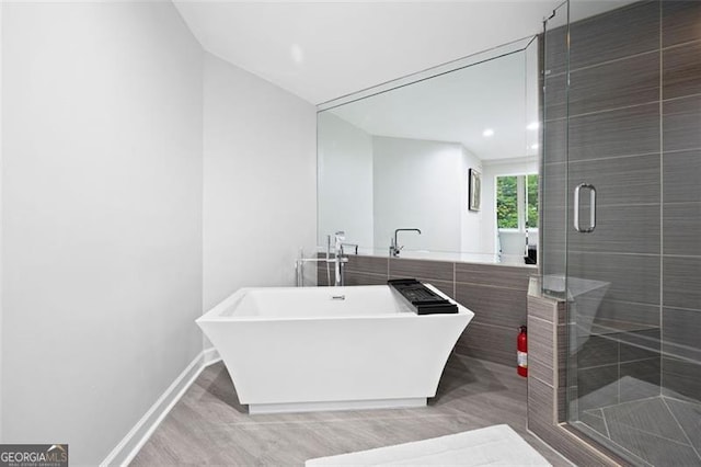 bathroom featuring separate shower and tub and hardwood / wood-style floors