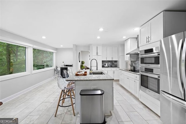 kitchen featuring white cabinetry, appliances with stainless steel finishes, sink, and an island with sink