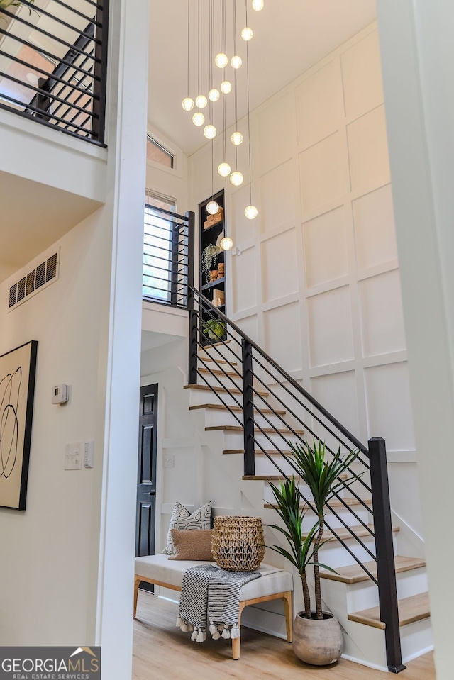 stairs featuring hardwood / wood-style floors and a towering ceiling