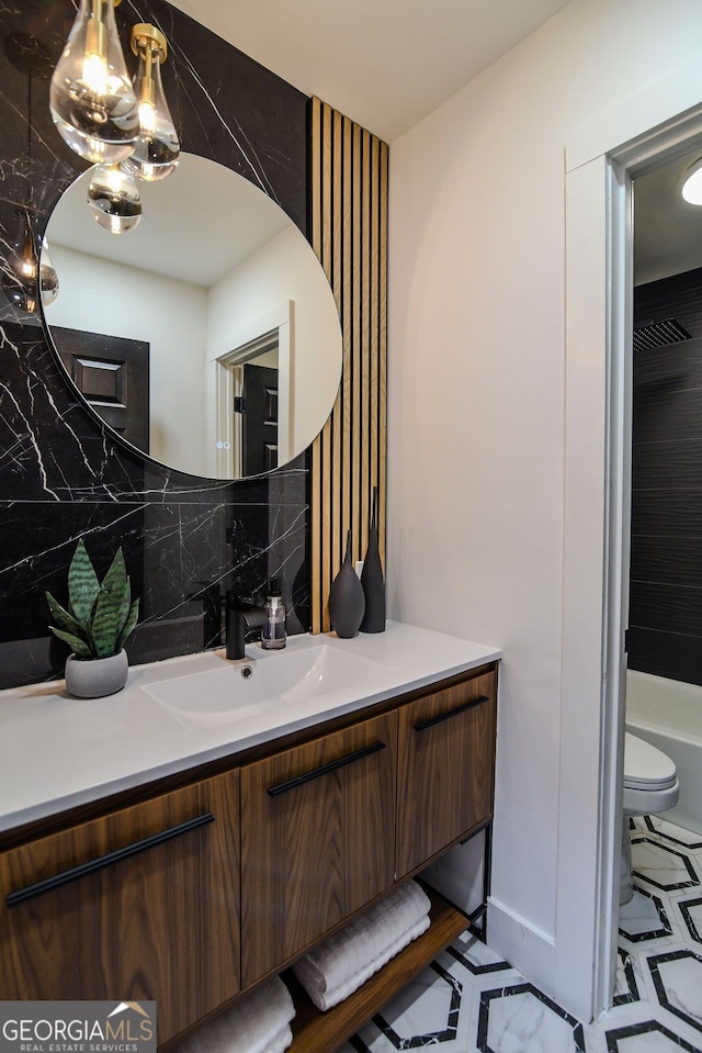 bathroom featuring decorative backsplash, toilet, a bath, and vanity