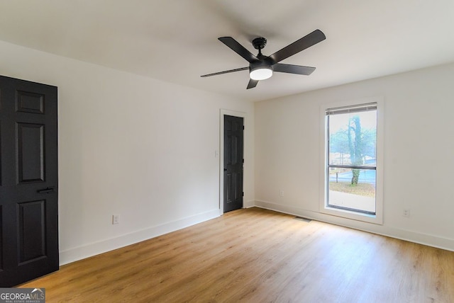 spare room with light wood-type flooring and ceiling fan