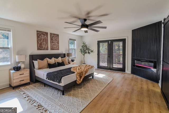 bedroom with ceiling fan, light wood-type flooring, access to outside, and french doors