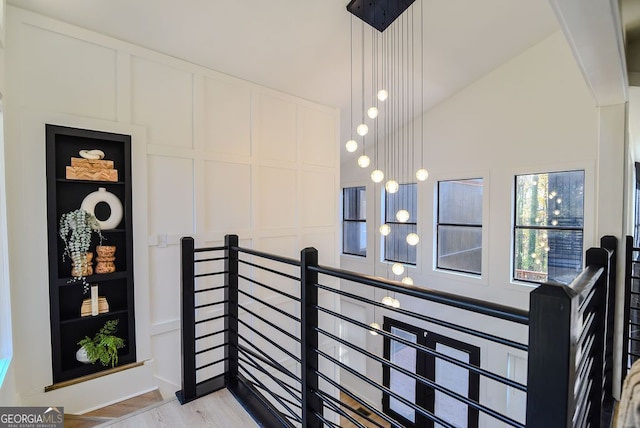 staircase with hardwood / wood-style flooring and lofted ceiling