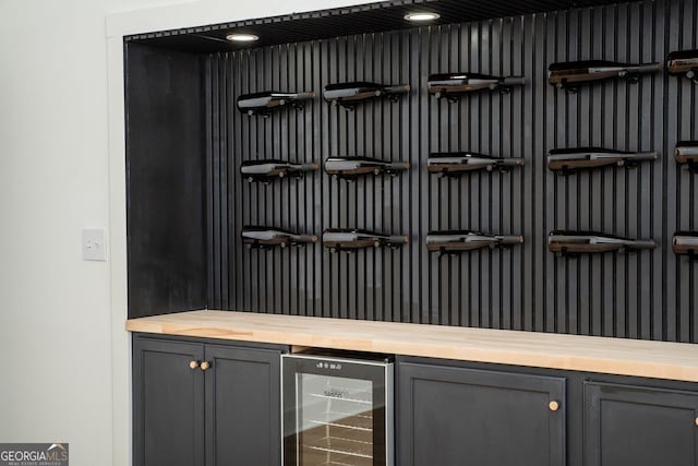 bar featuring butcher block countertops, gray cabinets, and wine cooler