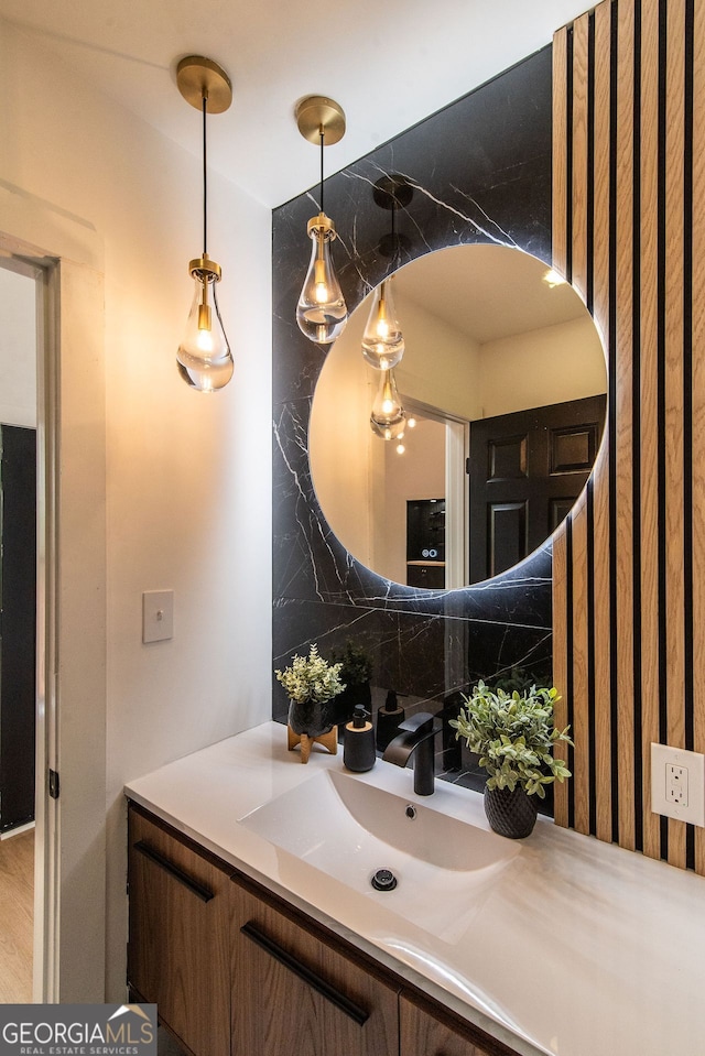 bathroom featuring tasteful backsplash, hardwood / wood-style floors, and vanity