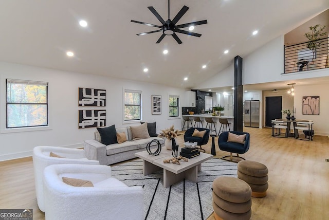 living room featuring ceiling fan, light hardwood / wood-style flooring, and high vaulted ceiling