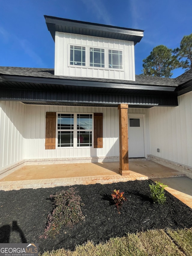 view of exterior entry with a patio