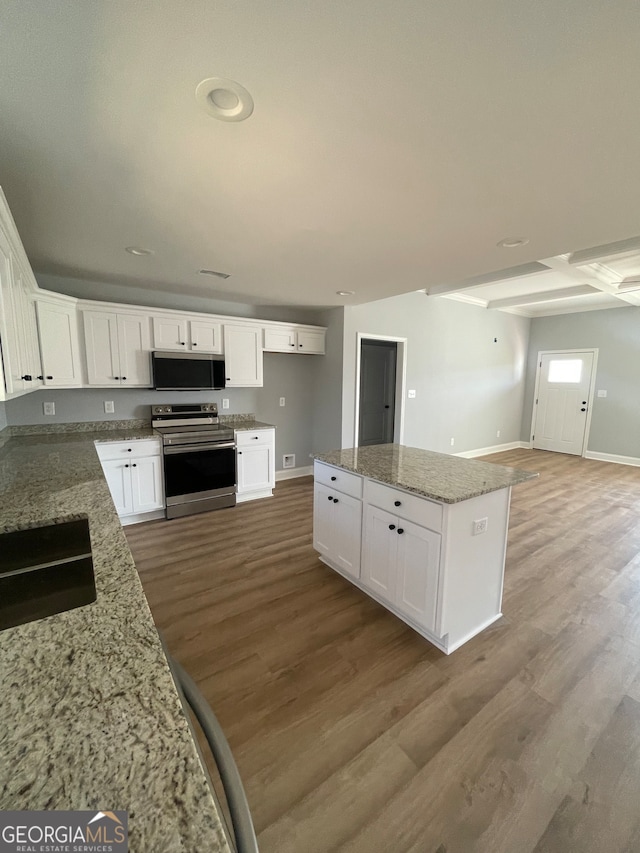 kitchen with light hardwood / wood-style floors, stainless steel appliances, light stone counters, and white cabinets