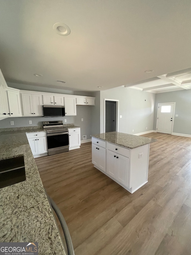 kitchen with light hardwood / wood-style floors, white cabinetry, light stone countertops, and stainless steel appliances