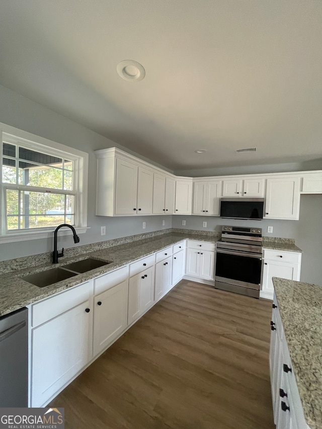 kitchen featuring dark hardwood / wood-style floors, stainless steel appliances, sink, white cabinets, and light stone counters