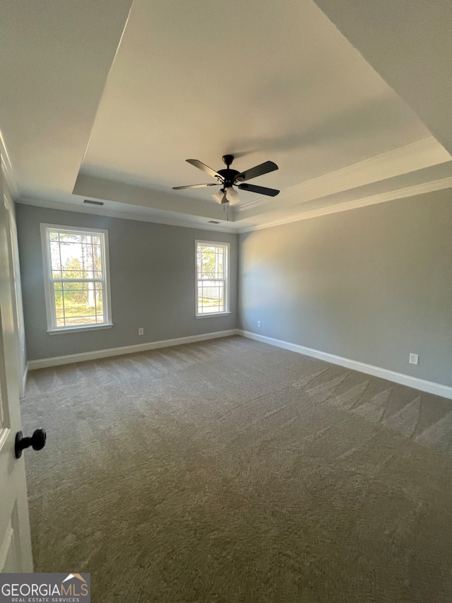 carpeted spare room with ceiling fan, a raised ceiling, and crown molding