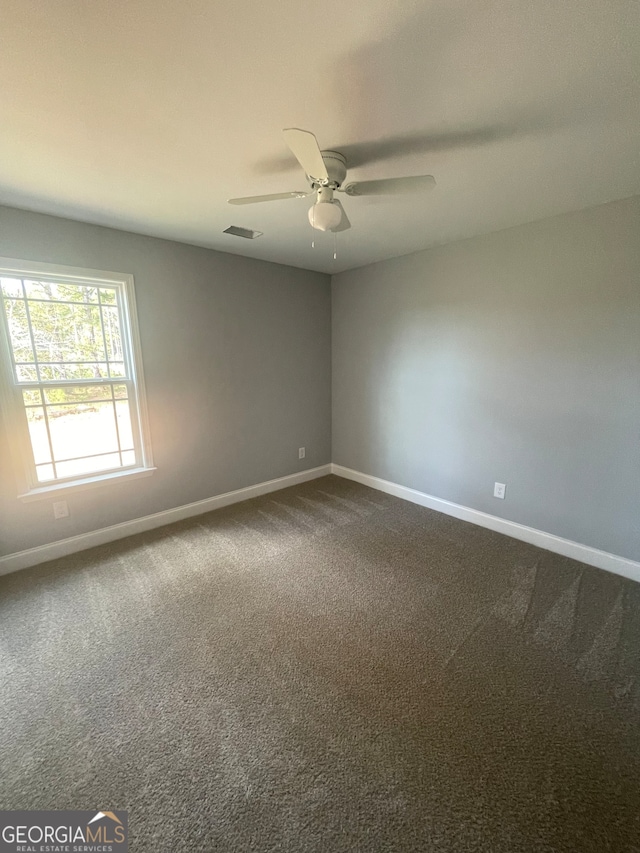 carpeted spare room featuring ceiling fan