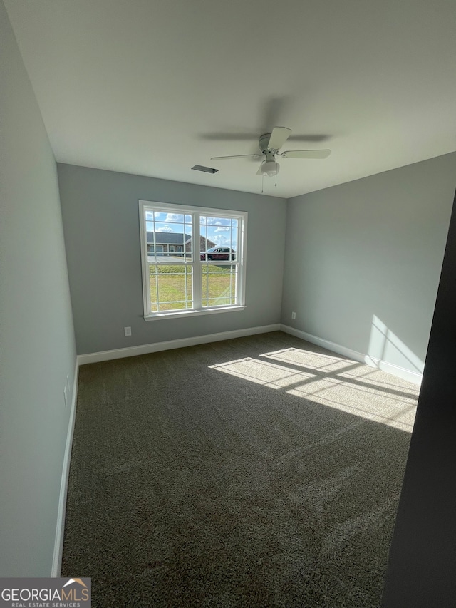 carpeted spare room featuring ceiling fan